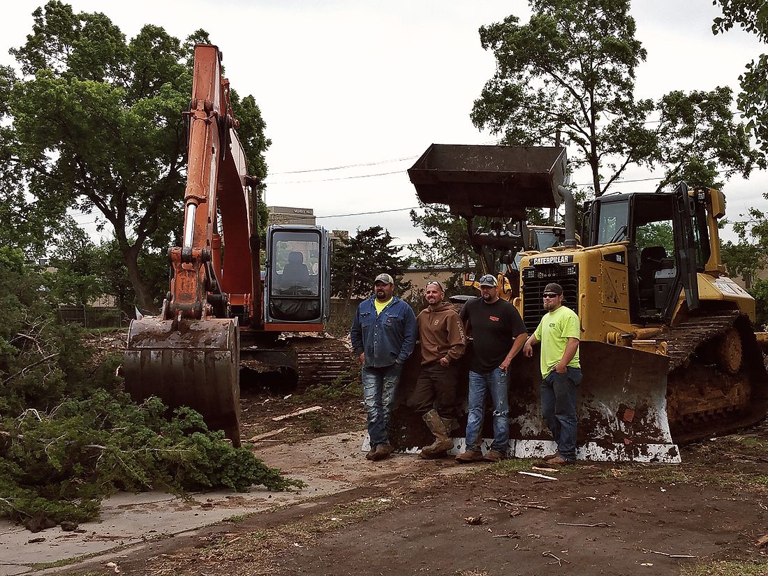 four men standing in front of bulldozer